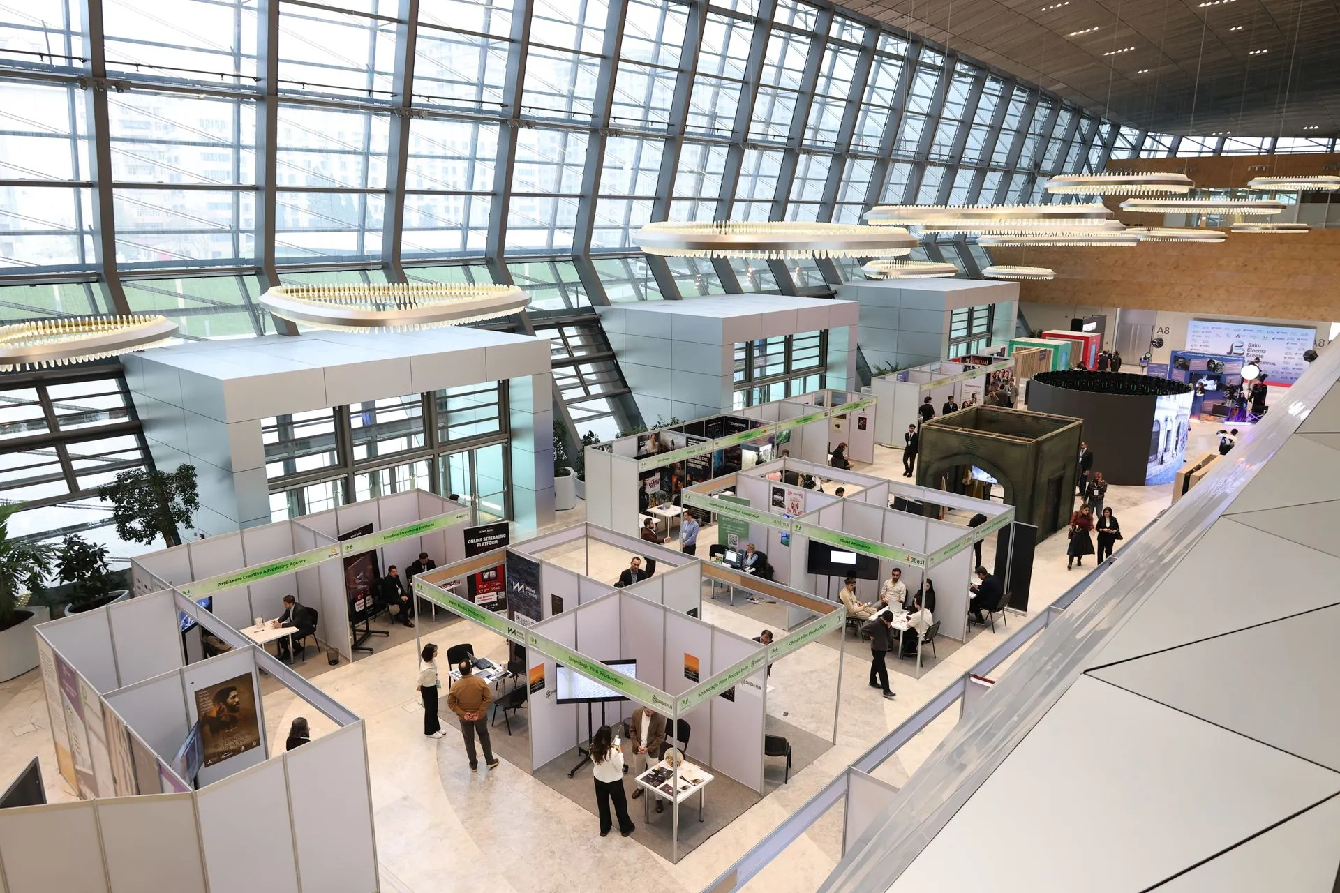 Exhibition hall floor with rows of stalls under a glass roof